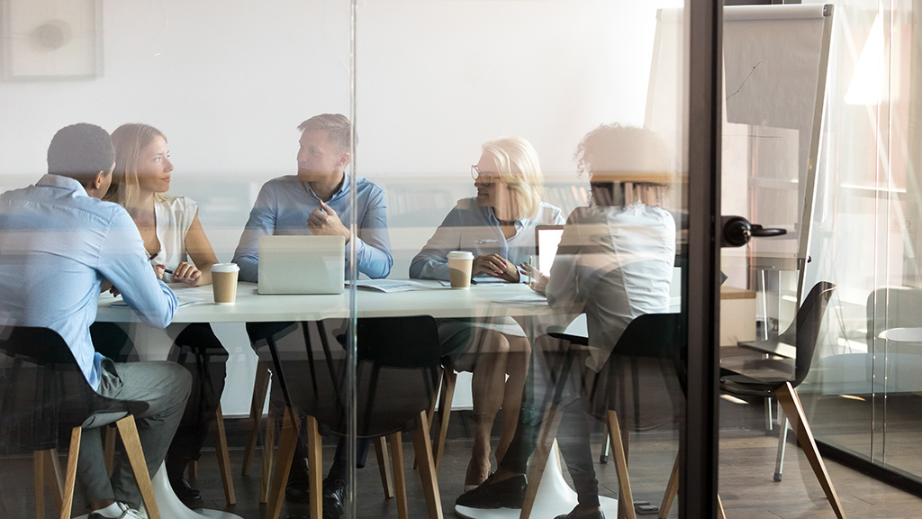 Professionals meeting in a conference room to discuss managed payroll services.